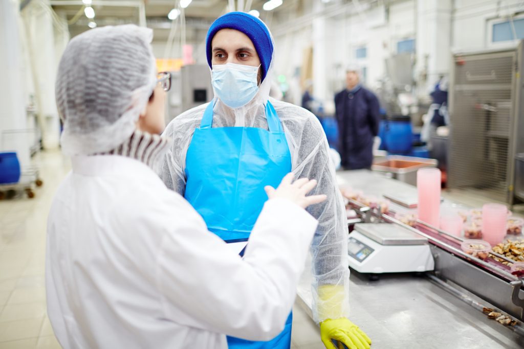 Two workers discussing SQF compliance